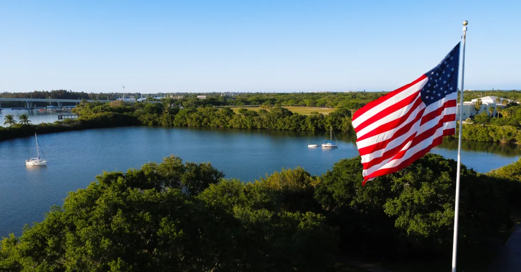 amerikanska flaggan över en sjö med båter i båt